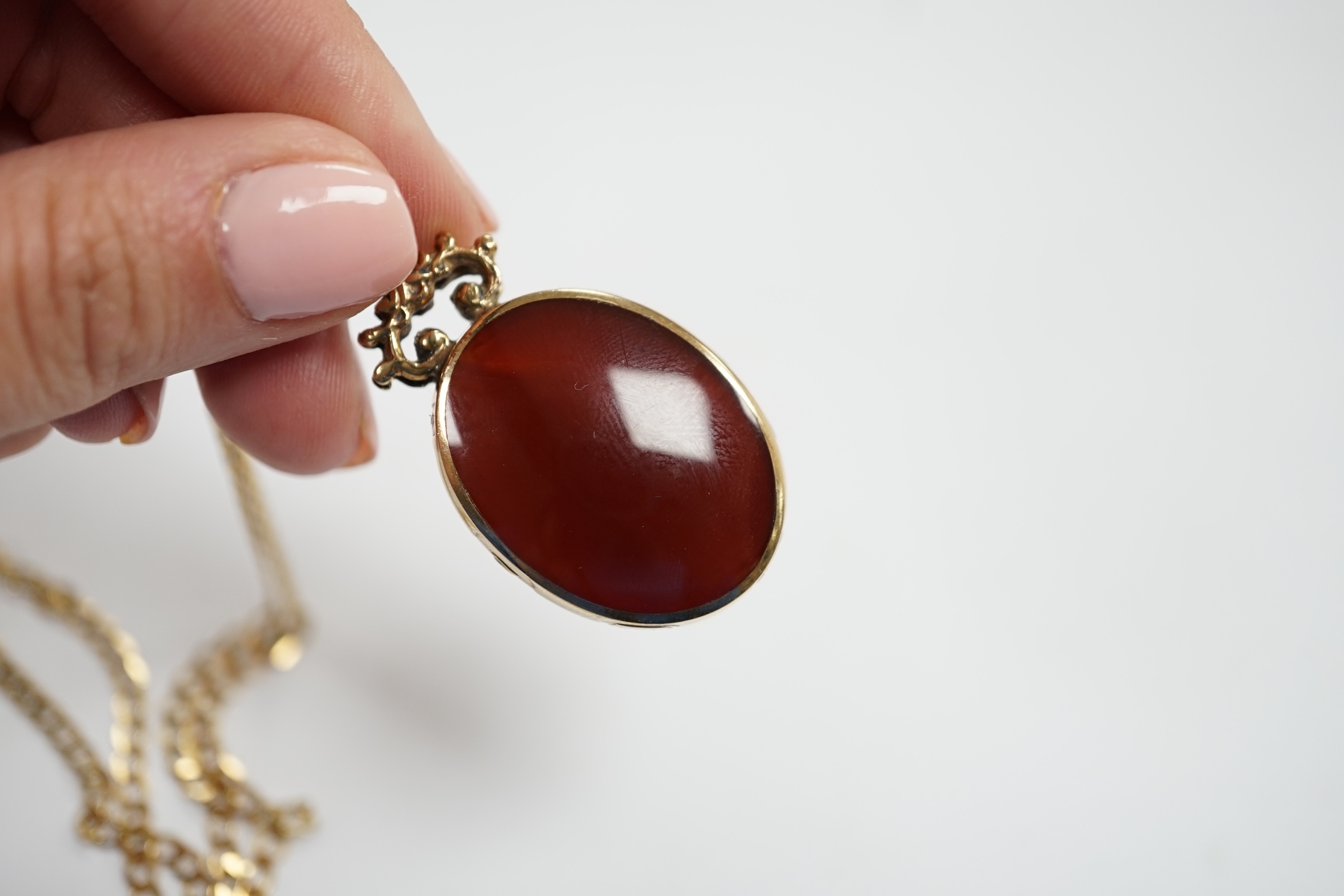 A modern 9ct gold mounted carnelian and bloodstone set oval 'Millennium' pendant, by Davis Scott Walker, overall 49mm, on a 9ct gold curb link chain, 50cm, gross weight 22.9 grams. Fair condition.